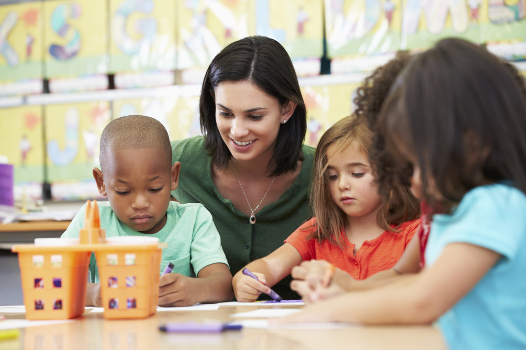 Group Of Elementary Age Children In Art Class With Teacher